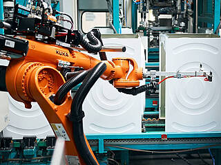 KUKA-Roboter handhabt in der Fertigung mit Waschmaschinen von BSH