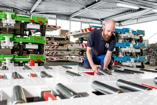 Man installiert die Tragrollen an einem Dolly