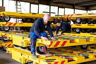 New airport dollies in factory hall with service technician