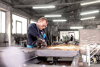 Man works in the production hall for airport ground equipment